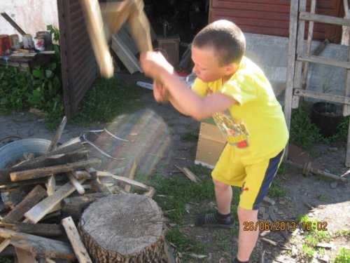 Восьмилетний внук колет дрова